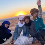 Travelers enjoying the sunset during a 2 Day Fes to Marrakech Desert Tour in Merzouga