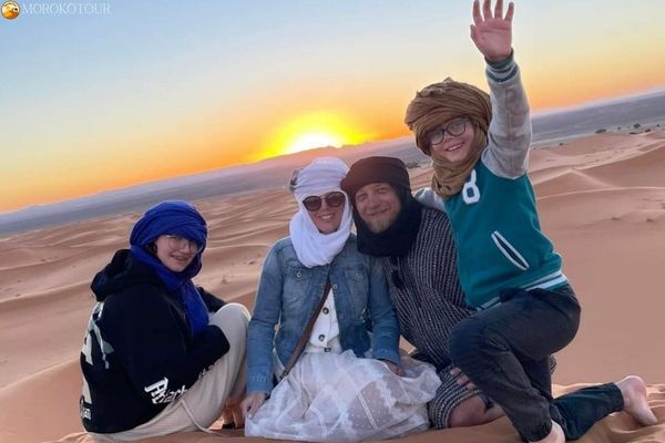 Travelers enjoying the sunset during a 2 Day Fes to Marrakech Desert Tour in Merzouga