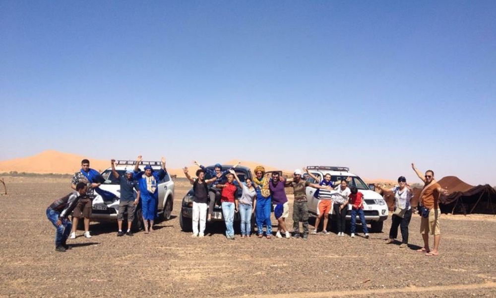 Group adventure on the 3-Day Morocco Desert Tour from Marrakech to Merzouga Tour group enjoying the Sahara dunes in Merzouga